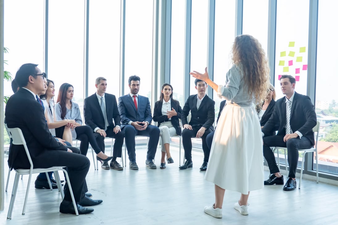 Woman Speaking in Front of the Business People